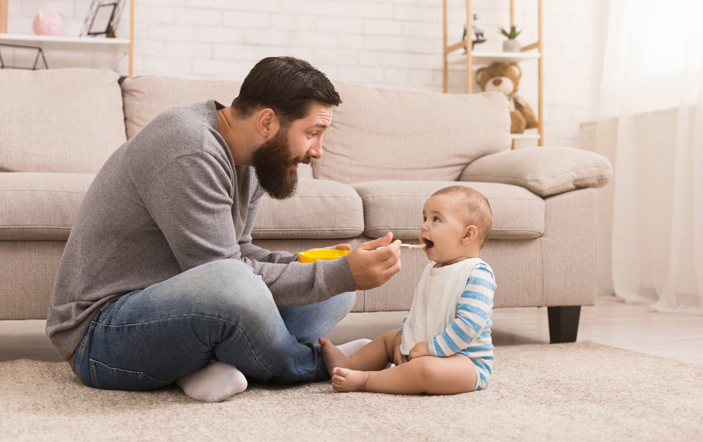 vater füttert baby